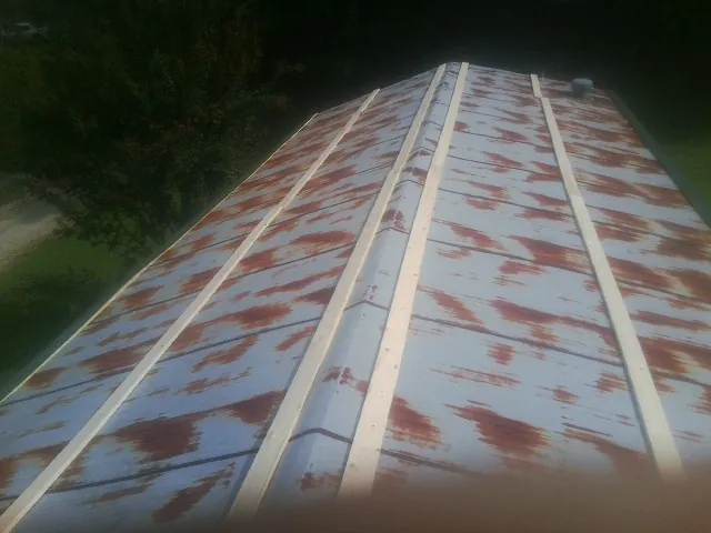 Rusted metal roof panels with new wood purlins before replacement — Storm Damage Roof Repair in Wonalancet by Roofing Brothers