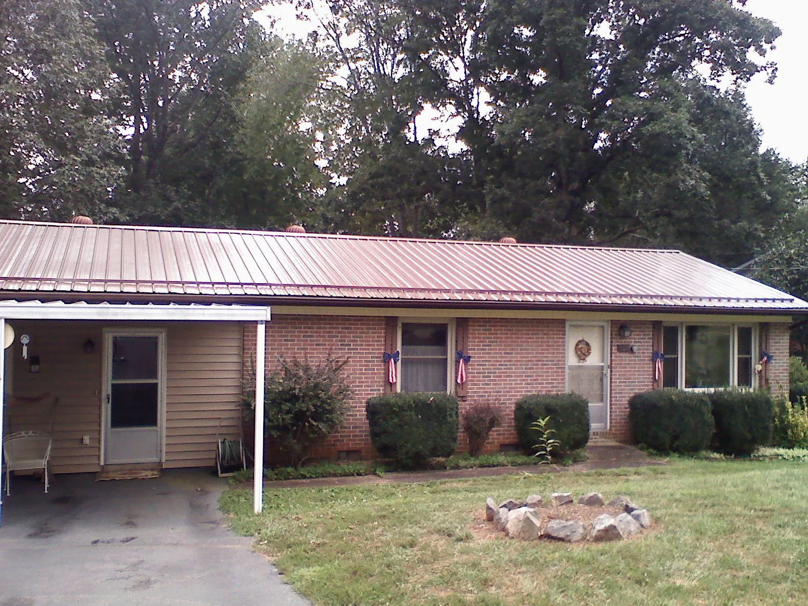 Bronze metal roof and carport on a brick ranch home — Roof Repair work by our crew in Wonalancet